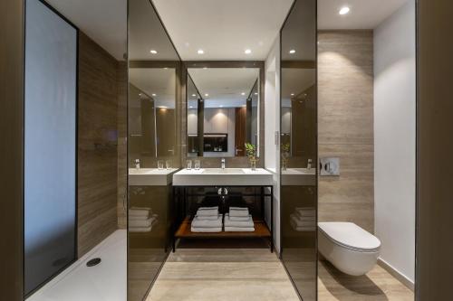 帕福斯Aliathon Ionian的浴室设有2个水槽、卫生间和镜子。