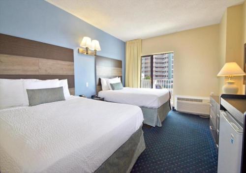大洋城海岸棕榈树客栈及套房酒店的酒店客房设有两张床和窗户。