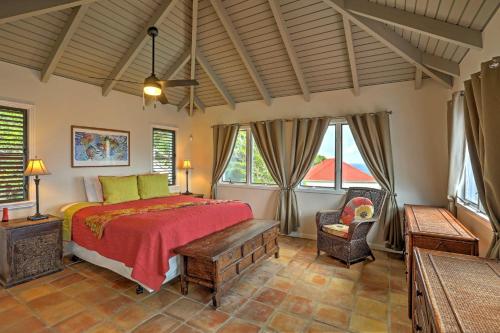 LovenlundSt Thomas Cliffside Villa with Pool and Hot Tub!的一间卧室配有一张床、一把椅子和窗户。