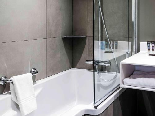 巴黎巴黎诺富特奥尔良门14酒店的带淋浴、浴缸和盥洗盆的浴室