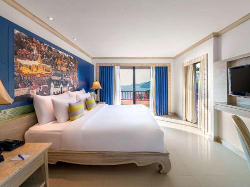 芭东海滩Novotel Phuket Resort的卧室配有一张白色大床和电视。