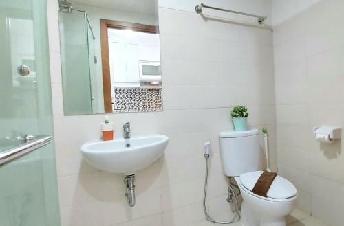雅加达Woodland Park Residence-Relaxed and Friendly的一间带卫生间、水槽和镜子的浴室