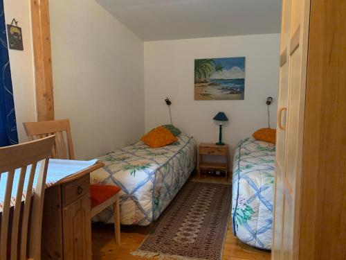 SvängstaAlmagården lantlig miljö的一间卧室配有两张床、一张桌子和一张书桌