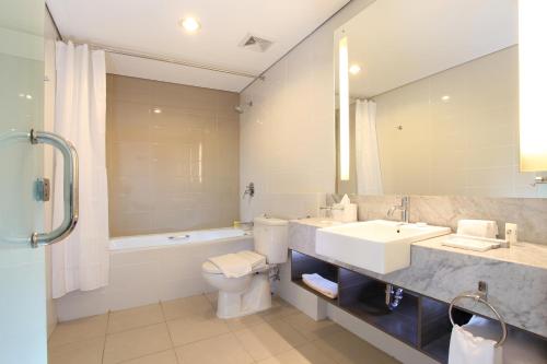巴厘巴板巴厘巴板瑞士博林酒店的一间带水槽、卫生间和镜子的浴室