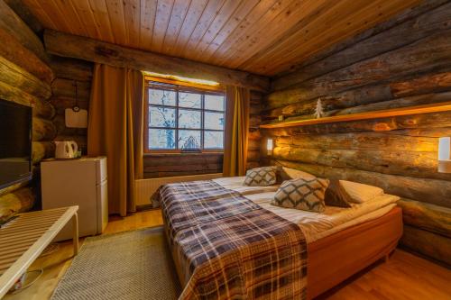 萨利色尔卡Kuukkeli Log Houses Teerenpesä的小木屋内一间卧室,配有一张床
