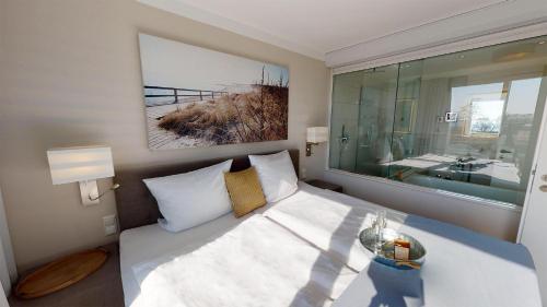 格洛米茨Beach'n'Sea Wohnung 7的一间卧室配有一张床,浴室设有大窗户