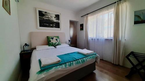 开普敦The Speckled Egg, 4 Promenade Rd, Lakeside, Cape Town的一间卧室设有一张大床和一个窗户。