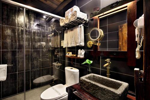 阳朔阳朔红楼梦酒店的黑色瓷砖浴室设有卫生间和水槽