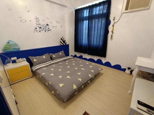 水里乡水里河堤咖啡民宿 Shuili Heti coffee B&B的一间卧室配有一张带蓝色床头板的床和窗户