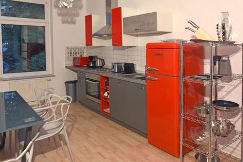 茨维考stylish city apartment in Zwickau的带桌子的厨房里的红色冰箱