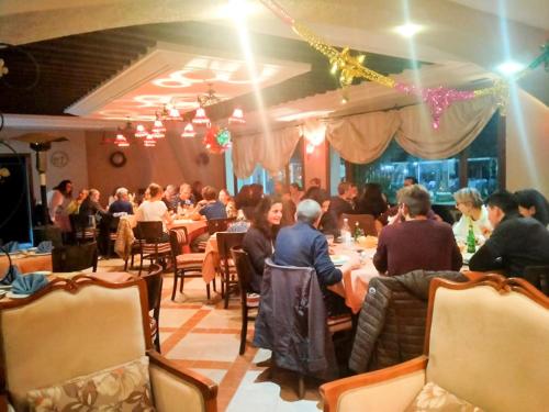 迈来亚Hotel de charme et SPA Dar El Bhar的一群坐在餐厅桌子上的人