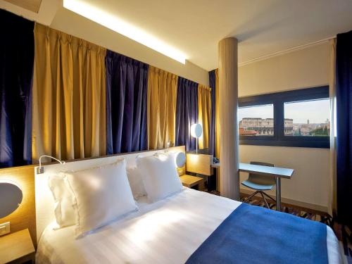 罗马罗马中央斗兽场美居酒店的配有一张床和一张书桌的酒店客房