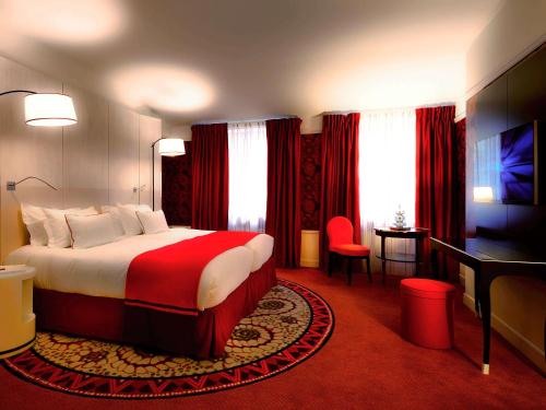 里昂Hotel Carlton Lyon - MGallery Hotel Collection的酒店客房设有一张大床和一张书桌。