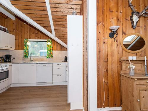 阿里尔6 person holiday home in Toftlund的厨房配有白色橱柜和木墙