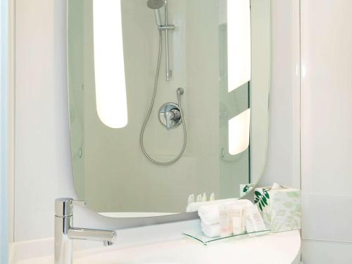 悉尼悉尼机场宜必思酒店的带淋浴和盥洗盆及镜子的浴室