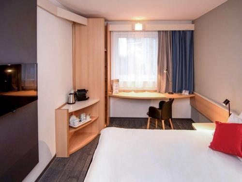 波兹南波兹南斯塔勒米亚斯托宜必思酒店的配有一张床、一张书桌和一扇窗户的酒店客房