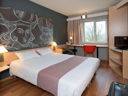 阿尔斯特ibis Aalst的酒店客房设有一张床,墙上挂有绘画作品
