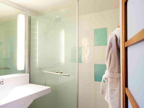 里尔诺沃特里尔中央车站酒店的浴室设有玻璃淋浴间和水槽