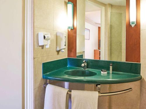 蒙特雷宜必思旺蒙特雷空港酒店的一间带绿色水槽和镜子的浴室