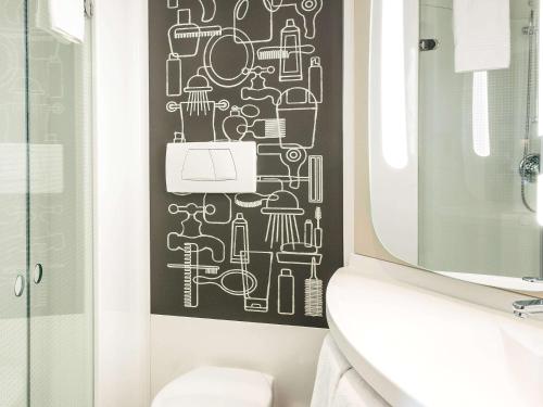 库尔布瓦宜必思巴黎拉德芳斯库尔布瓦酒店的浴室墙上有黑白图案