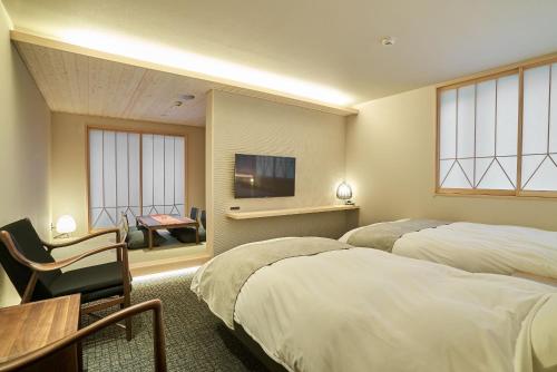 金泽凜庵 LIAN_KANAZAWA的酒店客房设有两张床和电视。