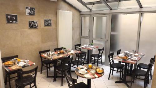 巴黎达拉普利斯德斯阿尔卑斯酒店的一间餐厅配有桌椅,提供食物