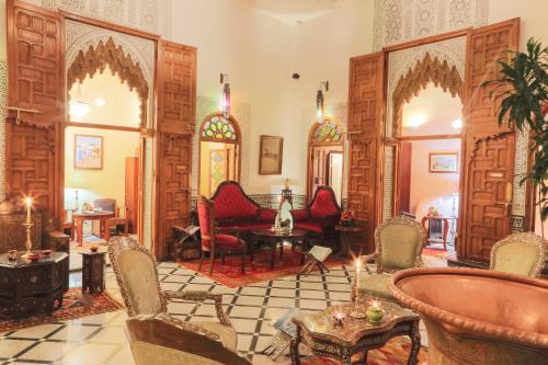 拉巴特卡巴莱歌舞表演摩洛哥传统庭院旅馆的客厅配有椅子和桌子。