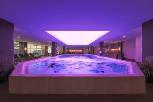 沙博伊茨格兰贝尔费德尔酒店的紫色照明的房子里的一个大型热水浴缸