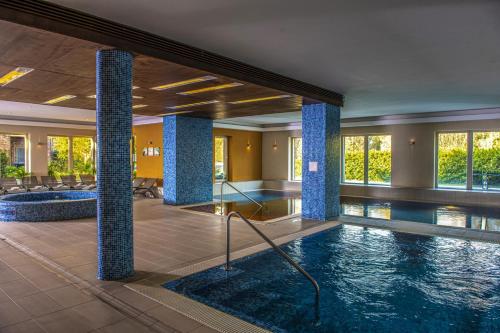 维谢格拉德皇家俱乐部酒店的酒店大堂设有游泳池和柱子