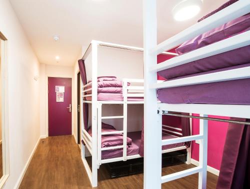 伦敦伦敦大象与城堡安全住宿旅舍的客房设有两张双层床和紫色床单