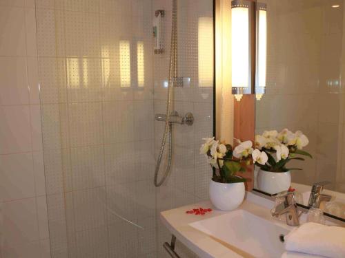 沙托鲁沙托鲁宜必思酒店的带淋浴和鲜花水槽的浴室