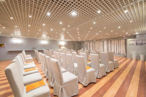 库马约尔皇家高尔夫豪华酒店的一间铺有木地板的白色椅子的房间