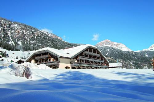 坎皮泰洛迪法萨Hotel Rubino Deluxe的一座山地雪地建筑
