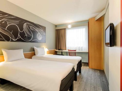 汉诺威汉诺威宜必思酒店的一间酒店客房,设有两张床和电视
