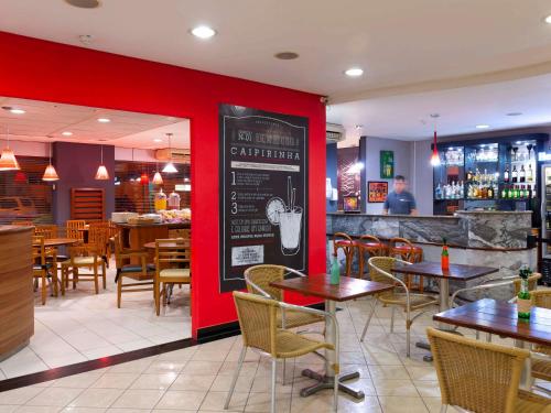 特雷西纳Ibis Teresina的一间带桌椅和红色墙壁的餐厅