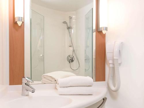 维特雷ibis Vitré Centre的带淋浴和毛巾水槽的浴室