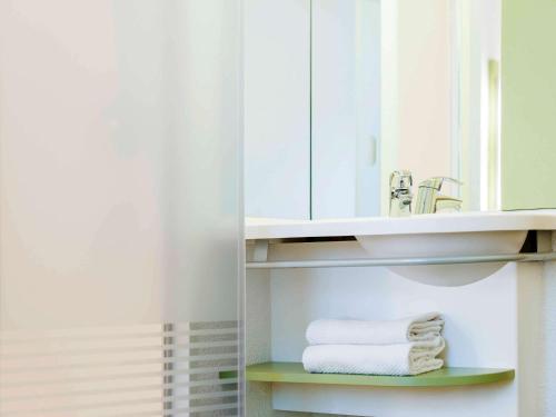 Ruisbroek布鲁塞尔南莱斯布鲁克宜必思快捷酒店的浴室配有盥洗盆、镜子和毛巾