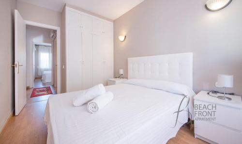 卡拉费尔Apartamento Montserrat 32-2的白色卧室配有一张大白色床和2条毛巾