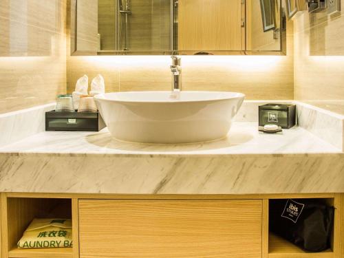 Huangxing长沙会展宜必思尚品酒店的一间带水槽和台面的浴室