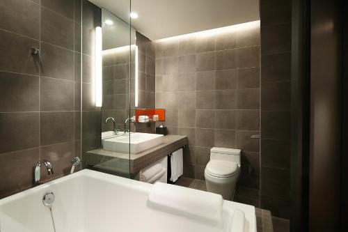 华城市新罗东滩住宿酒店的带浴缸、卫生间和盥洗盆的浴室