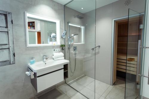 帕绍Passau - Suites的一间带水槽和玻璃淋浴的浴室