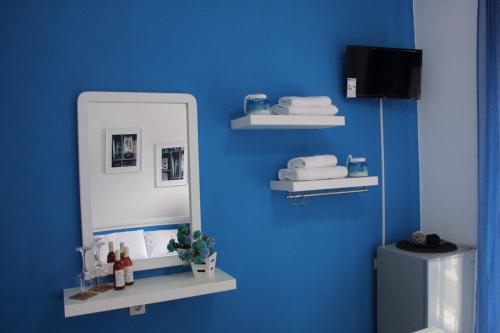 皮加迪卡Hotel Elena的浴室设有镜子和蓝色的墙壁