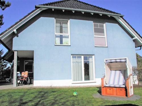 巴贝Ferienhaus Morgenstern F403 mit Kamin und Garten的庭院里带椅子的蓝色房子