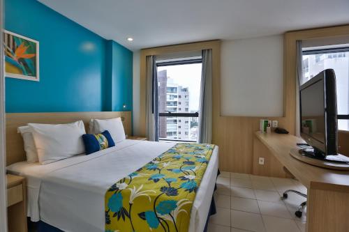 马瑙斯马瑙斯品质酒店的一间卧室配有一张床、一张书桌和一台电视