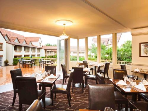 堪培拉堪培拉美居酒店的餐厅设有桌椅和窗户。