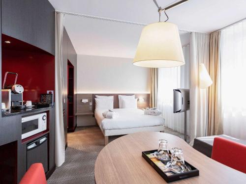 日内瓦日内瓦机场诺富特套房酒店的酒店客房配有一张床铺和一张桌子。