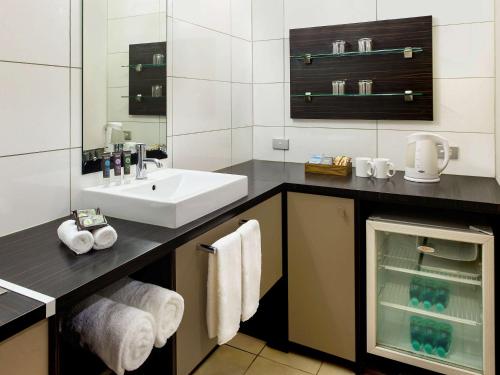南迪诺富特纳迪酒店的一间带水槽和白色水槽的浴室