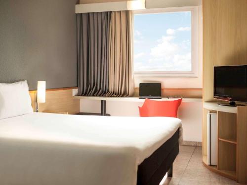 克里西玛ibis Criciuma的酒店客房设有床和窗户。