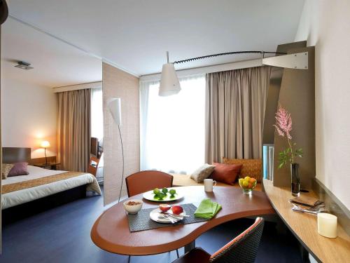 波尔多波尔多艾达吉奥公寓式酒店的酒店客房设有一张桌子和一张床