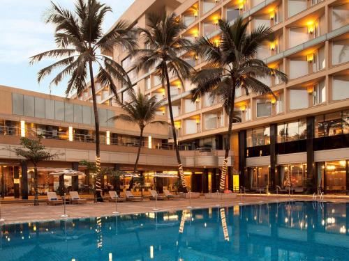 孟买孟买珠瑚海滩诺富特酒店的大楼前设有游泳池的酒店